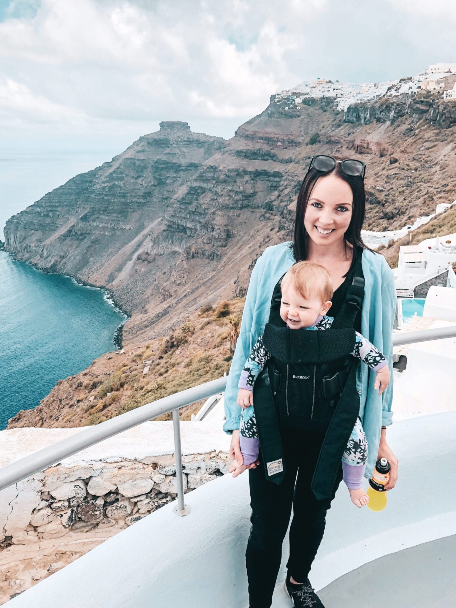 Mum & baby in Baby Bjorn carrier in Santorini, Greek Islands. Travel with a baby to Santorini for the most memorable family holiday. 